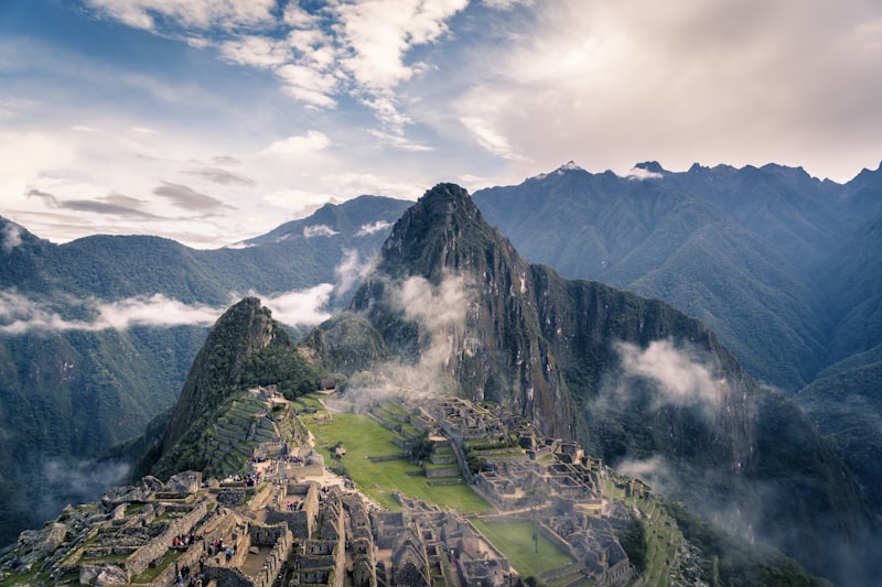 Ancient Incan ruins of Machu Picchu surrounded by misty green peaks in Peru