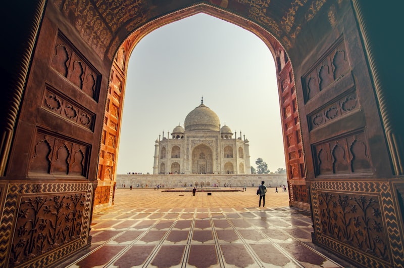 The Taj Mahal reflected in still water at sunrise in Agra, India